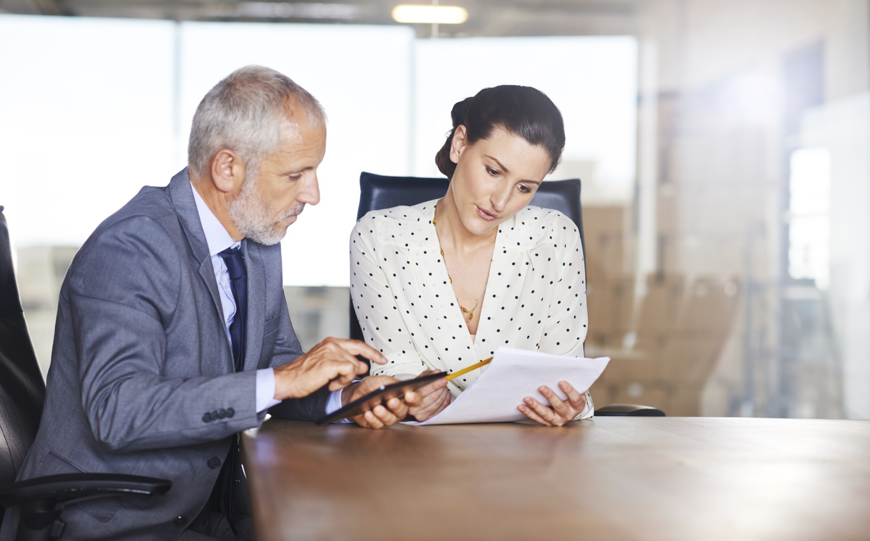 Two individuals studying documents