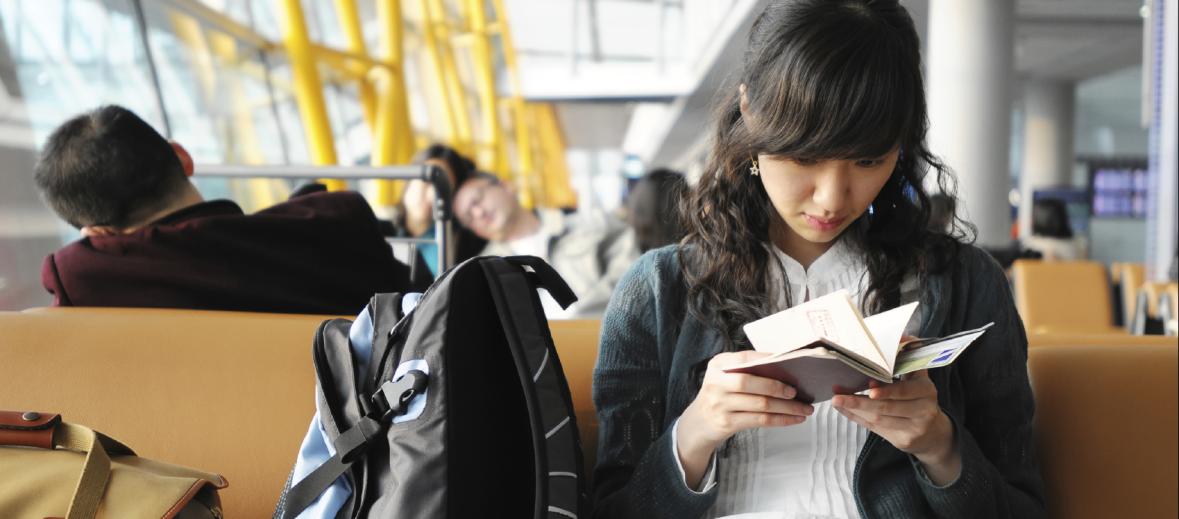 Person reading next to backpack