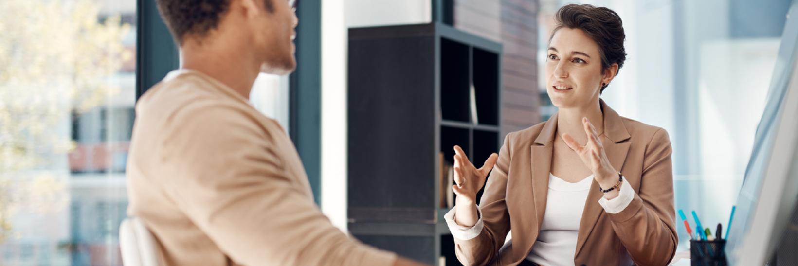 An SEVP field representative sits in an office with a designated school official and discusses SEVP regulations