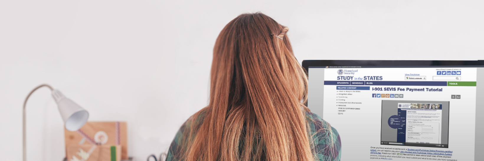 Girl sitting at a desk, facing a computer screen