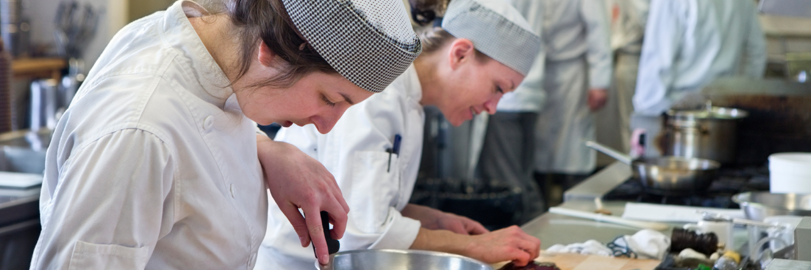 A culinary student slicing meat in class. 