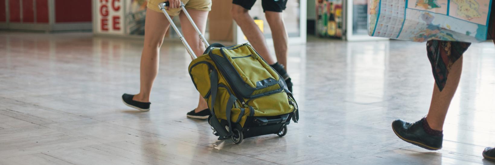 Students walking with their luggage through the airport