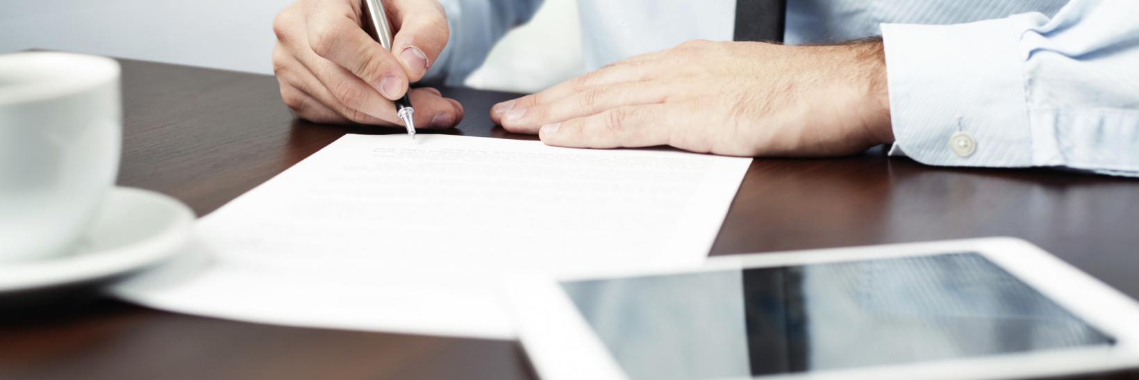 man signing a contract