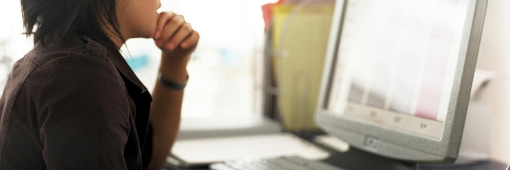 woman sits at a computer