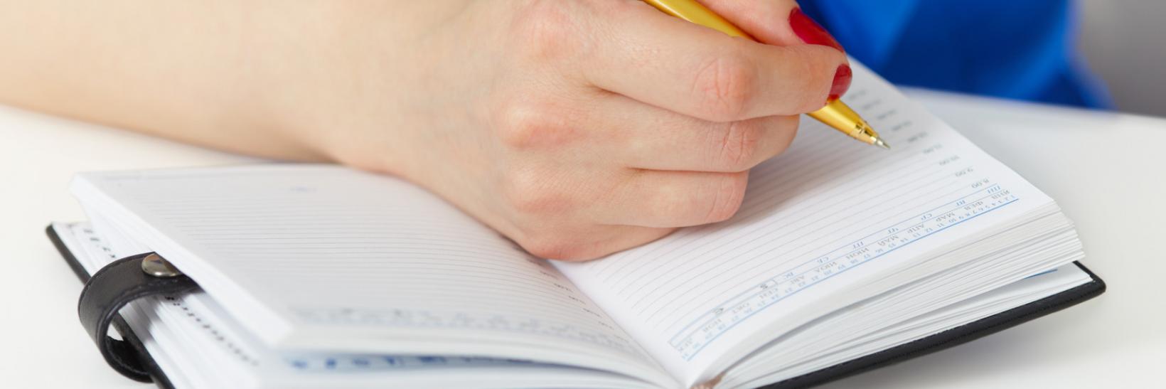 Student taking notes on how to maintain their status