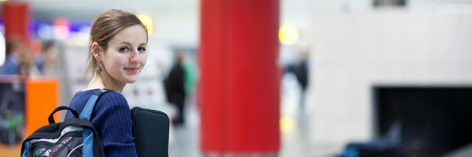 Woman at airport baggage claim. 