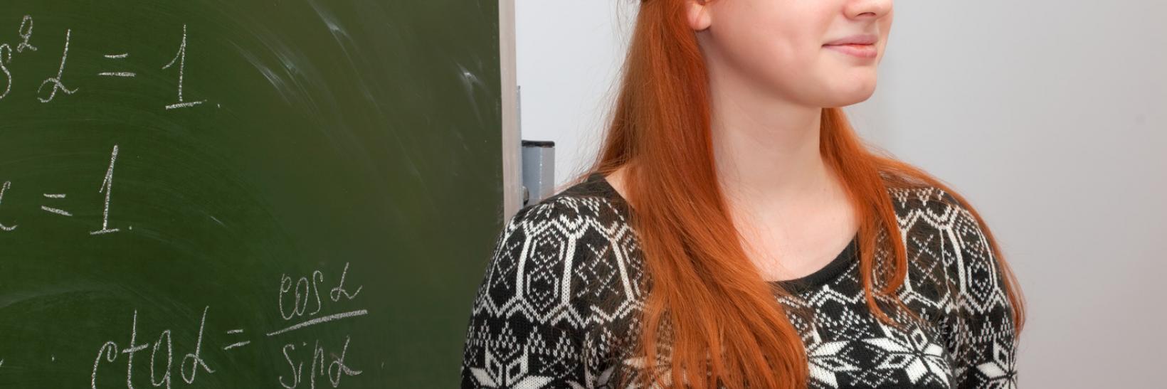 Woman standing in front of blackboard