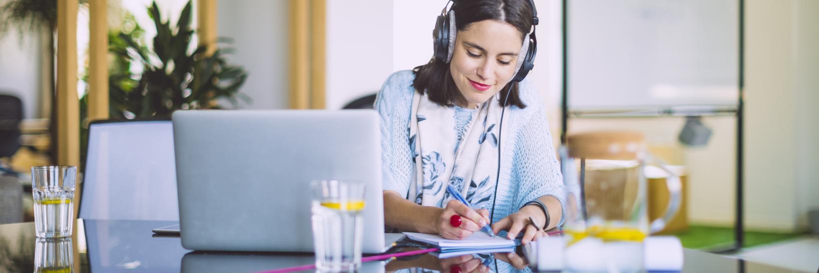 Woman wearing headphones at a computer