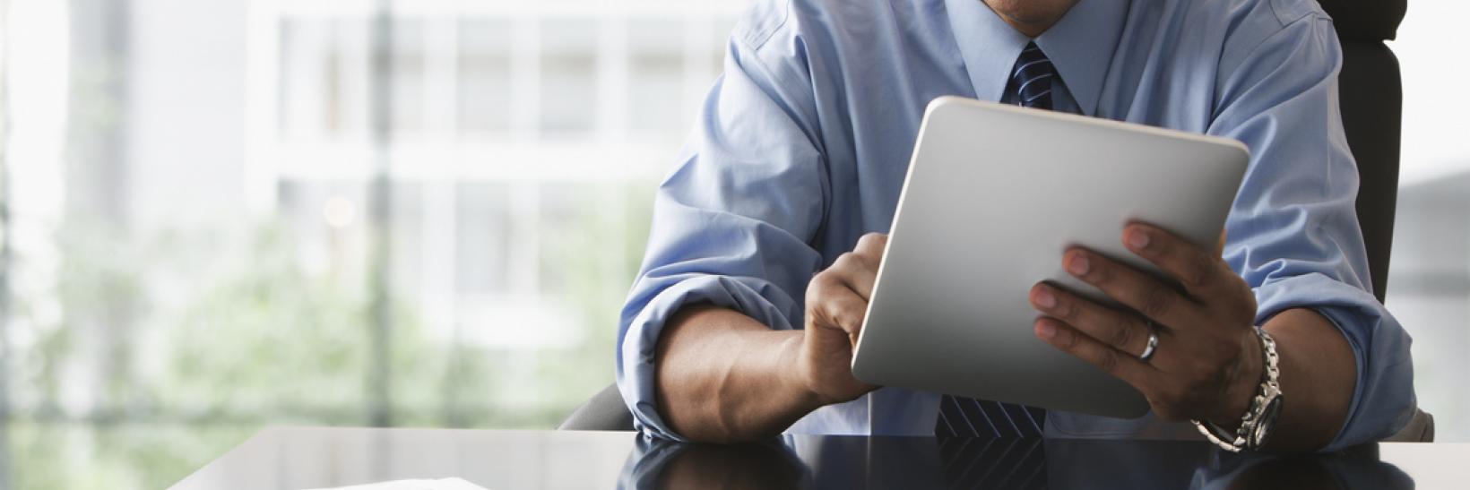 A man reading on a tablet. 