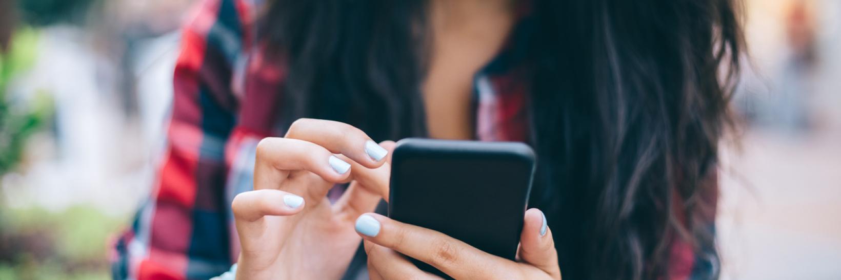 Girl texting on smartphone outside