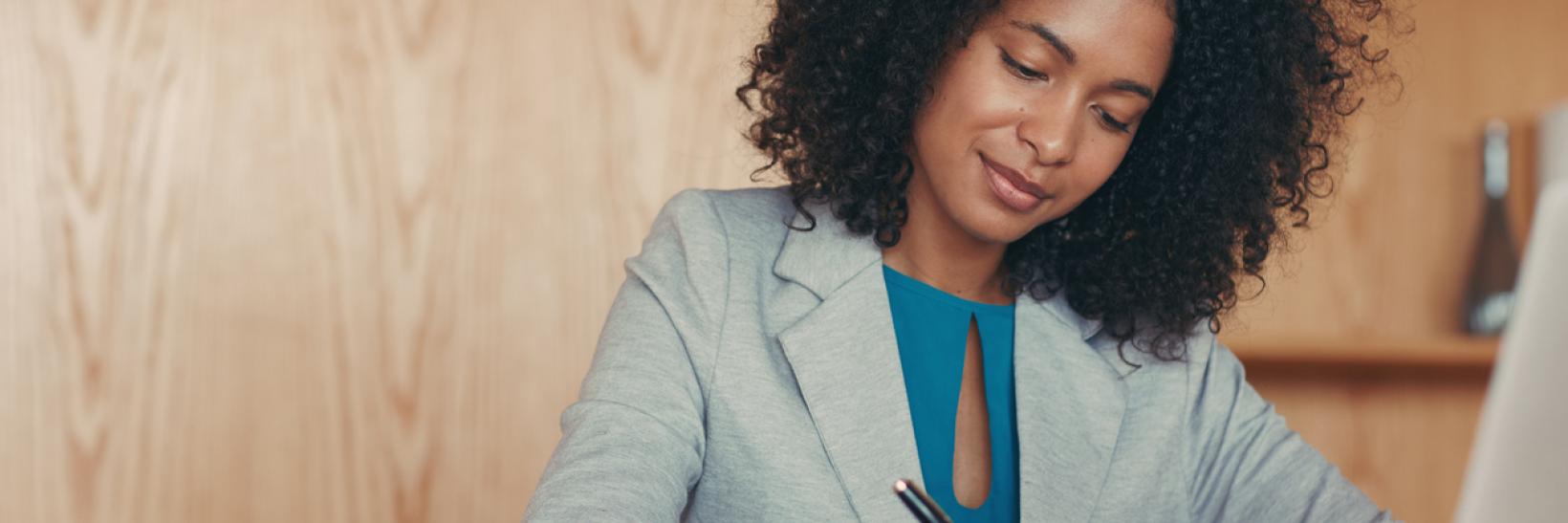 A woman writing on a notepad. 