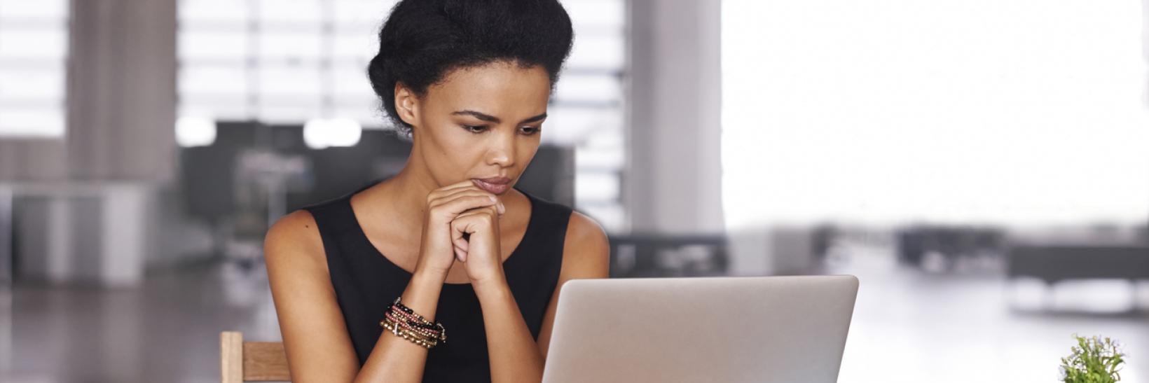 A woman looking at her laptop computer.