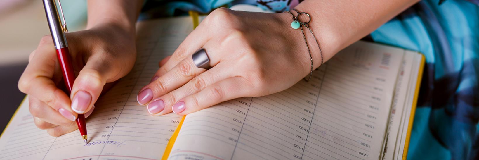 A woman is writing notes and planning schedule