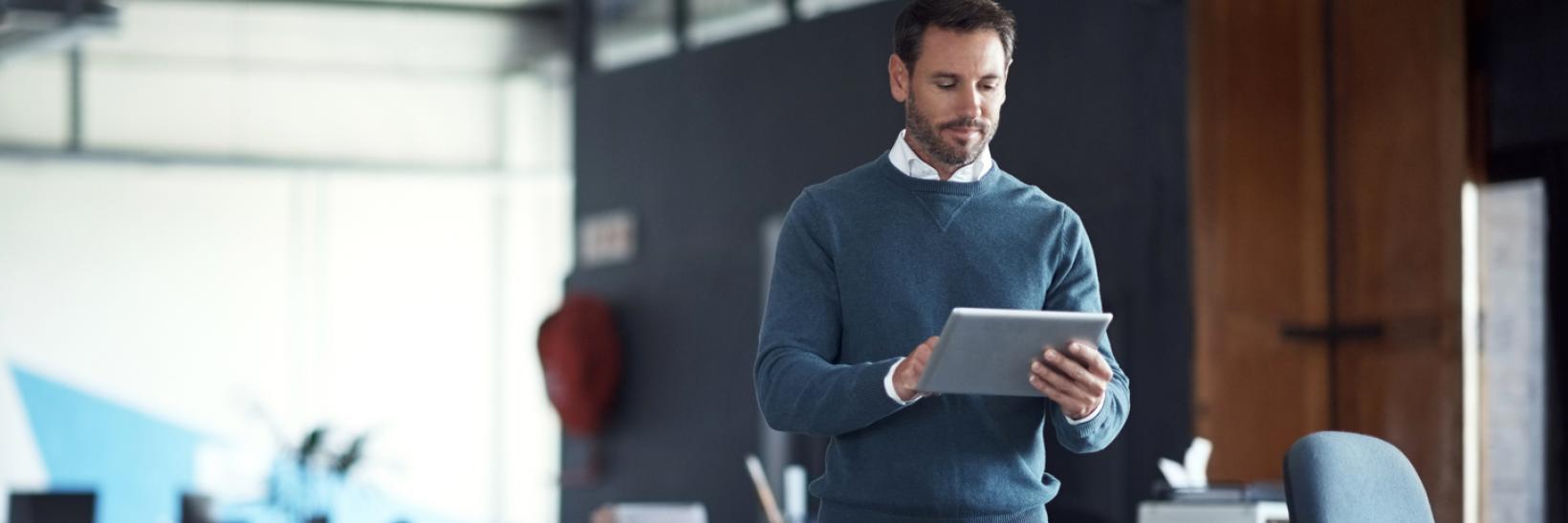 A man looking at a tablet computer.