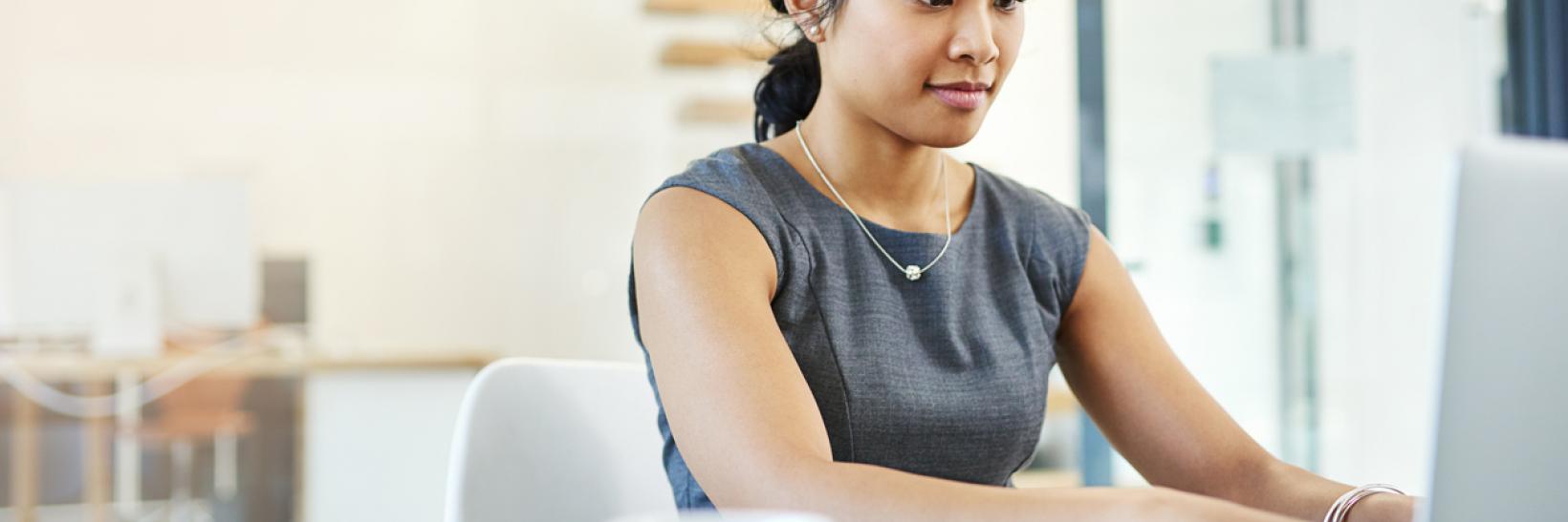 A woman typing on a laptop computer.