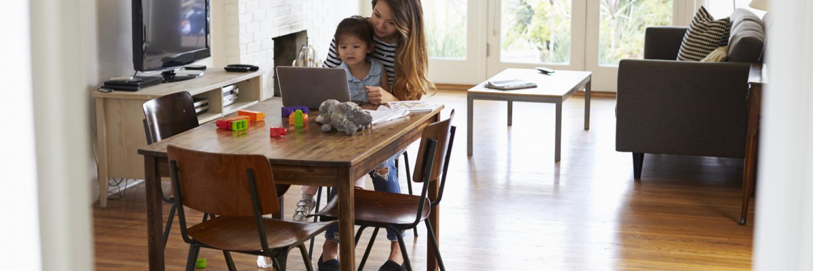 A mother and her child working on a laptop