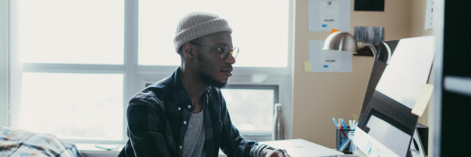 African american student working in his bedroom office