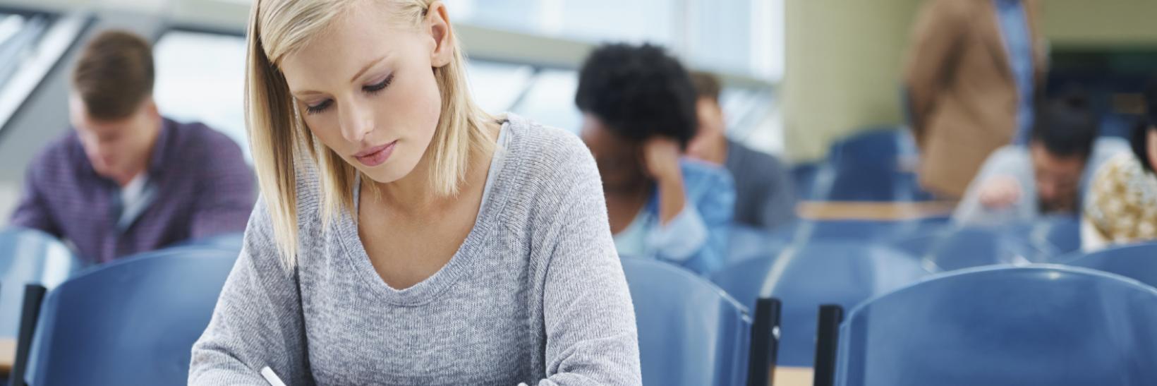 Young woman taking a scantron test at a table. 