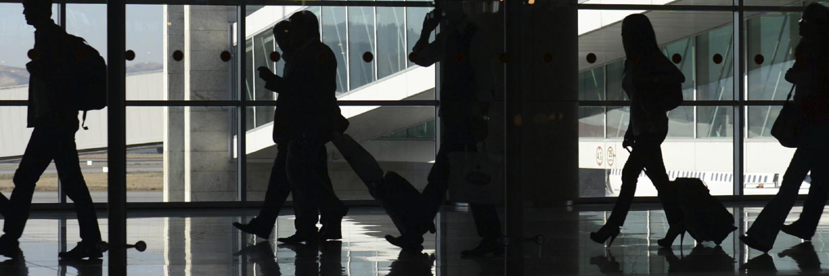 Silhouettes of travels in an airport terminal 