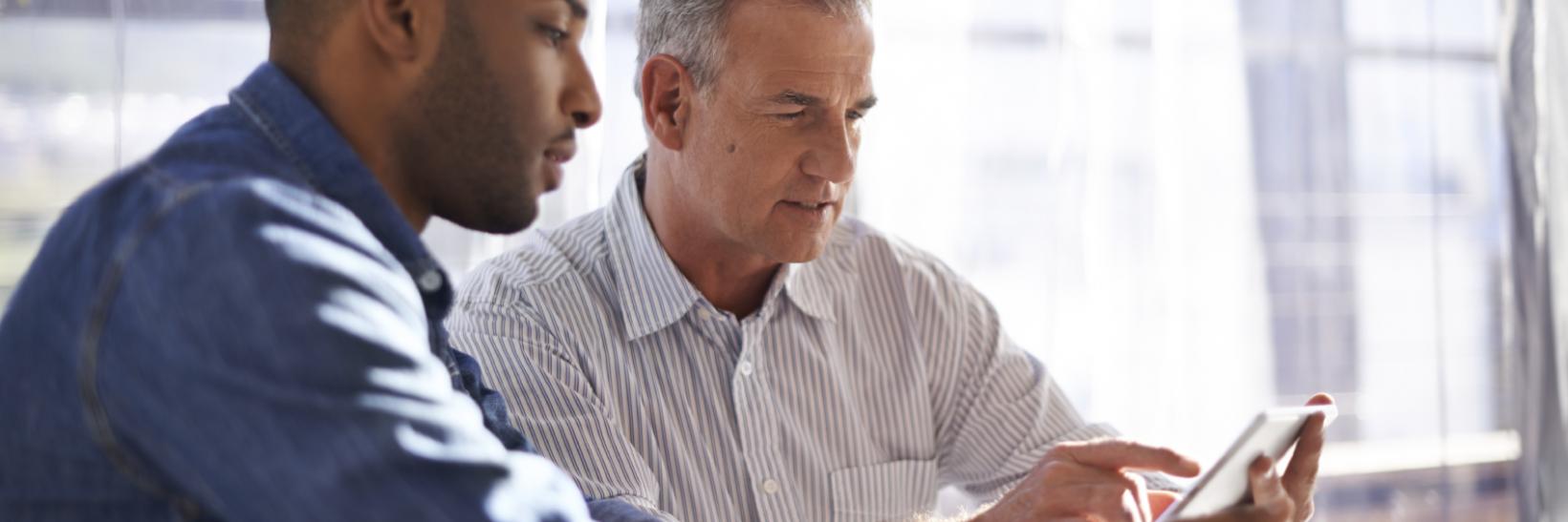 Two men working together at a table. 