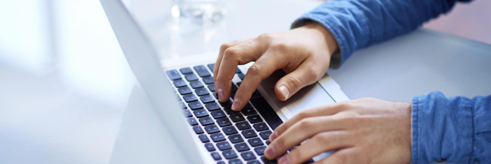 birds eye view of man typing on laptop 