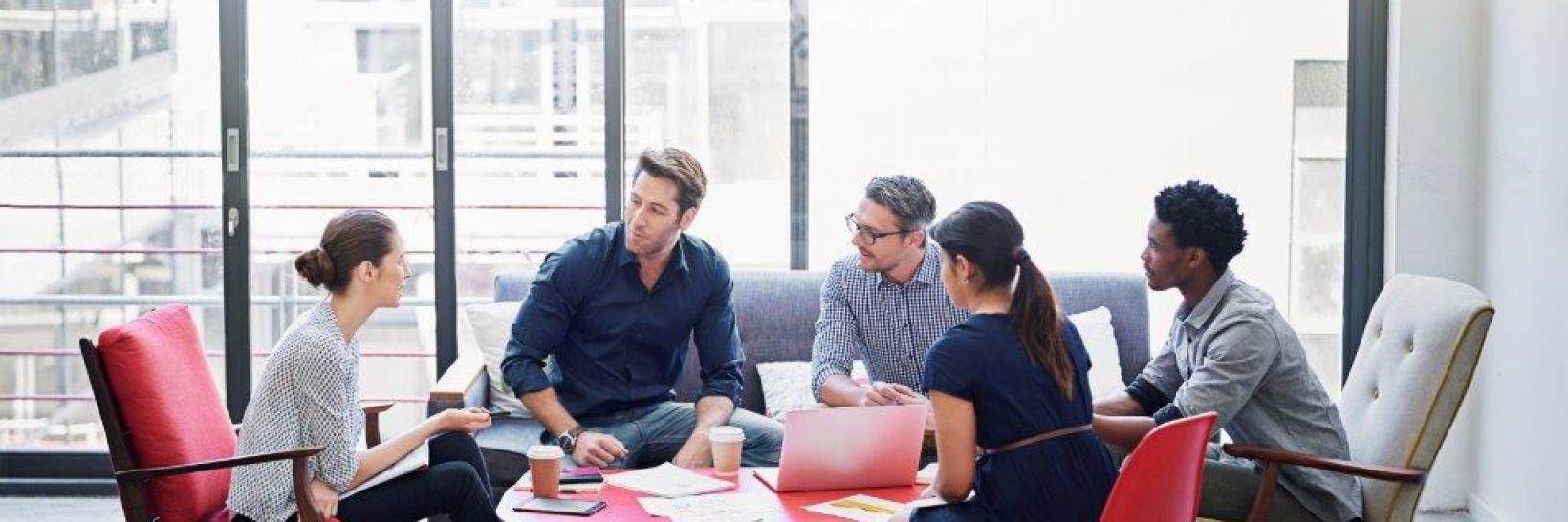 A group of people talking around a table.