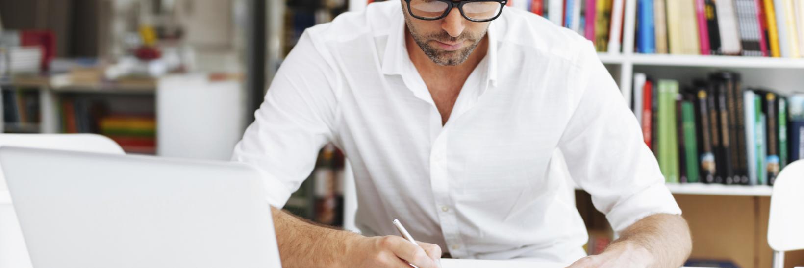 A man writing on his notepad.