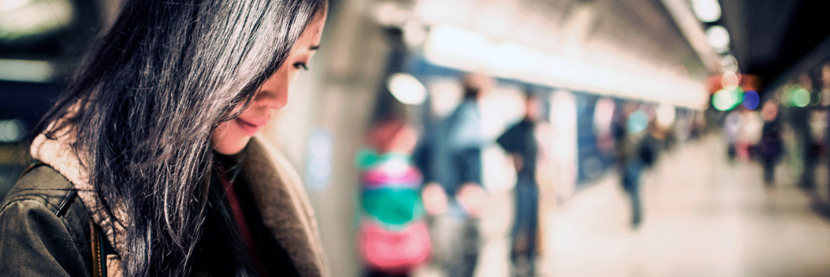 A woman on her phone in a subway station.