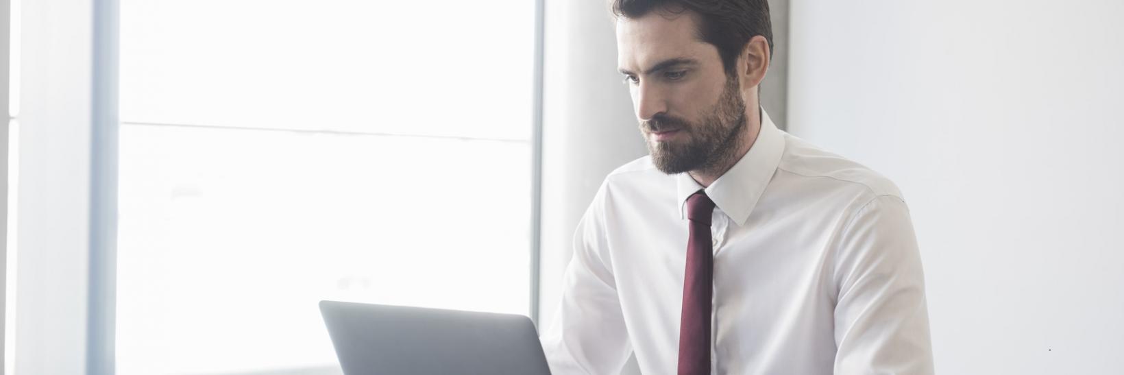 Man in a business suit using a laptop computer at a desk