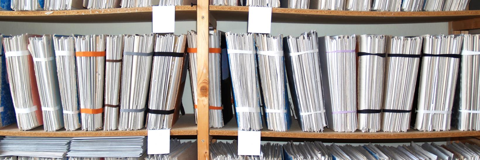 Paper files on a shelf.