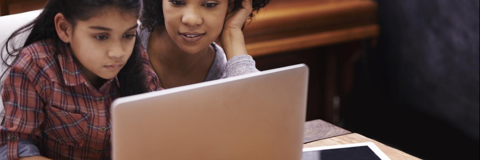 Mother and daughter viewing laptop