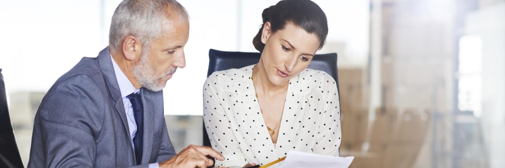 Two individuals studying documents