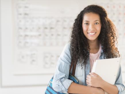 girl holding school books in class