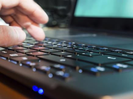 person types on a laptop