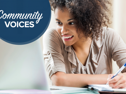 Young woman smiling and taking notes from a computer screen. Community Voices header upper left hand corner