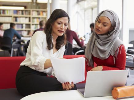 Two women reading a document.