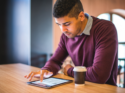 A man reading the SEVP Spotlight on a tablet. 