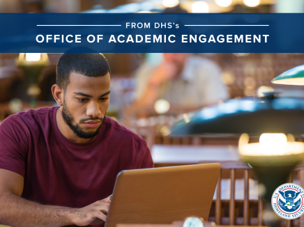Young male looking at an open laptop computer in a library with the DHS logo in the right hand corner and text that reads, "From DHS's Office of Academic Engagement"
