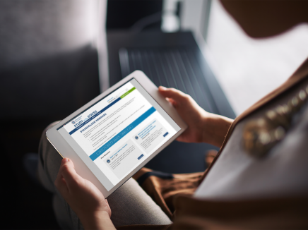 A woman holding a tablet viewing the stakeholder webinars page