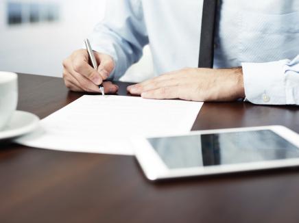 man signing a contract