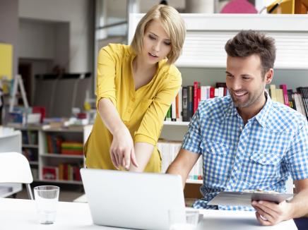 two people working at a laptop