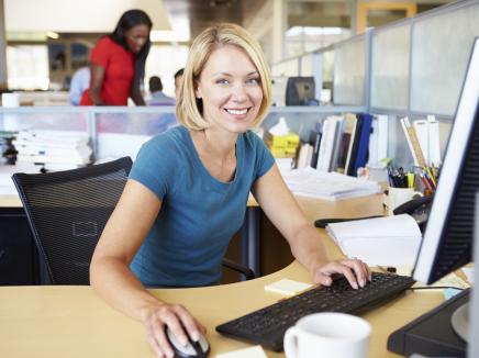 young woman sits at a computer