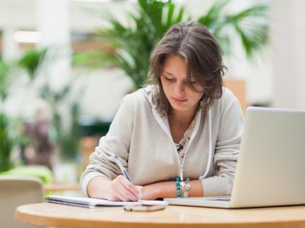 girl taking notes at a laptop