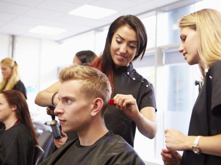 Teacher helping students training to become hairdressers