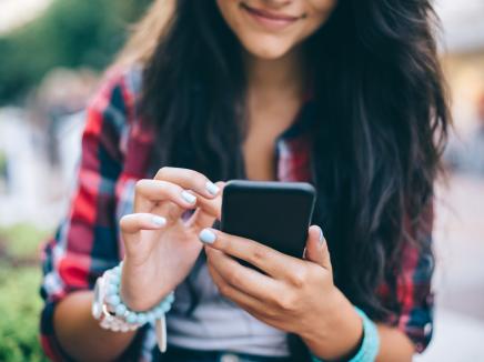 Girl texting on smartphone outside