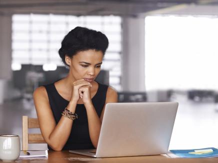 A woman looking at her laptop computer.