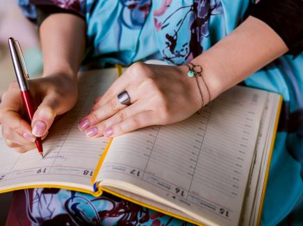 A woman is writing notes and planning schedule