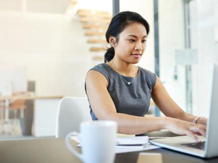 A woman typing on a laptop computer.