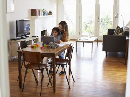 A mother and her child working on a laptop