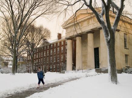 Student walking on a snowy college campus 